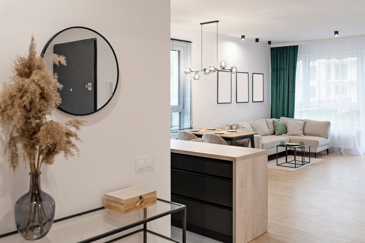 Living room of a serviced apartment with wooden floors and a dining table by a large window