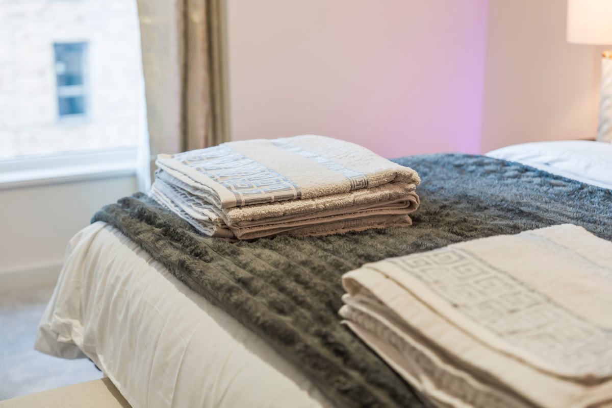 Folded textile samples arranged on a bed in the bedroom at Wedgewood
