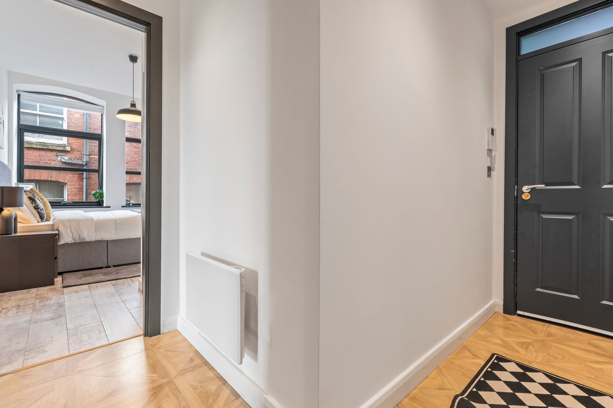 Hallway at The Calls with hardwood flooring and a doorway through to a bedroom with city views